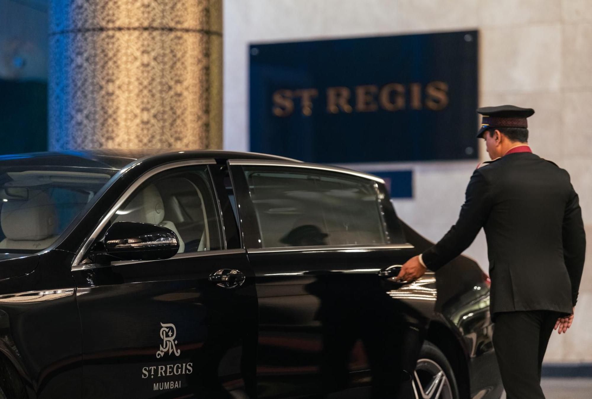 Hotel The St. Regis Bombaj Exteriér fotografie A chauffeur opening the door of a car
